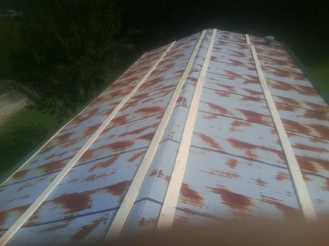 Rusted metal roof panels with new wood purlins before replacement — Storm Damage Roof Repair in Freeman by Roofing Brothers